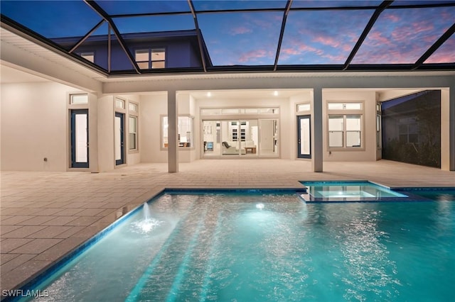 view of swimming pool featuring a patio, a pool with connected hot tub, and a lanai