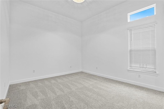 empty room featuring baseboards and carpet