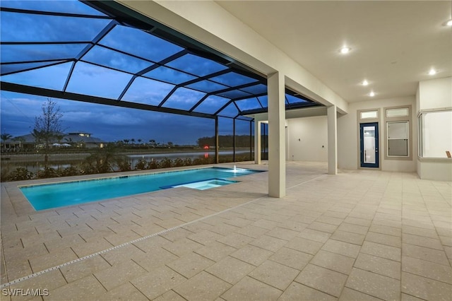 pool with a hot tub, a patio area, and a lanai