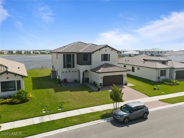 view of front of house featuring a garage, a tiled roof, decorative driveway, a front yard, and stucco siding