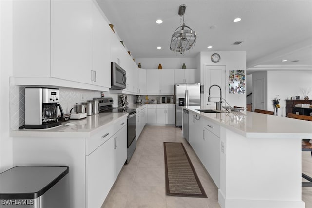 kitchen featuring light countertops, appliances with stainless steel finishes, backsplash, and white cabinets