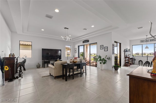 living room with visible vents, a raised ceiling, a wealth of natural light, and light tile patterned flooring