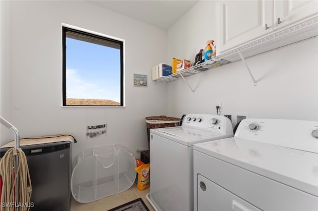 clothes washing area with tile patterned flooring, cabinet space, and washer and clothes dryer