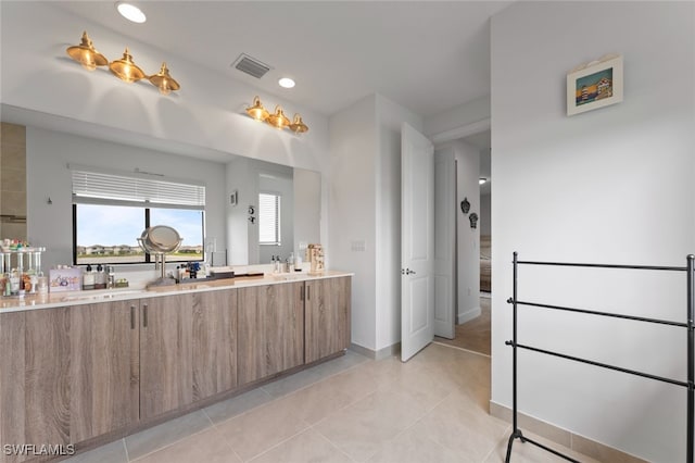 bathroom featuring tile patterned flooring, visible vents, plenty of natural light, and double vanity