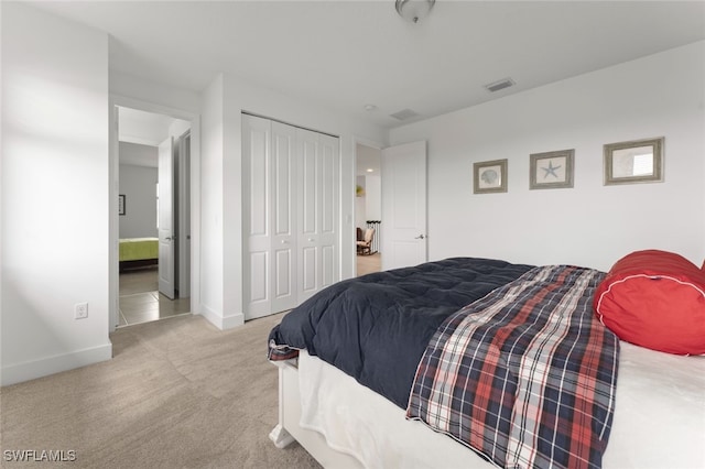 carpeted bedroom featuring a closet, visible vents, and baseboards