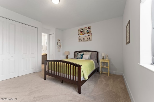 bedroom with baseboards, multiple closets, and light colored carpet