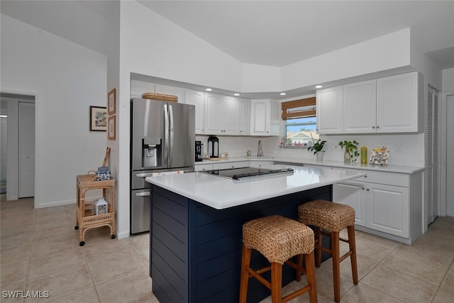 kitchen featuring light tile patterned flooring, light countertops, a sink, and stainless steel fridge with ice dispenser