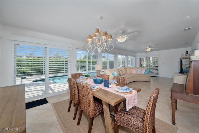 dining space with ceiling fan with notable chandelier, light tile patterned flooring, and visible vents