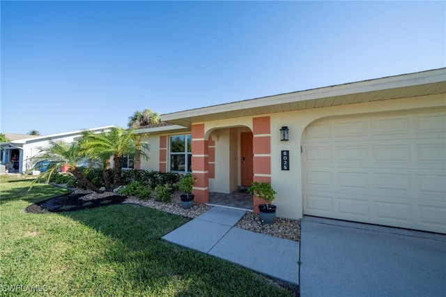 single story home featuring a garage, stucco siding, and a front yard