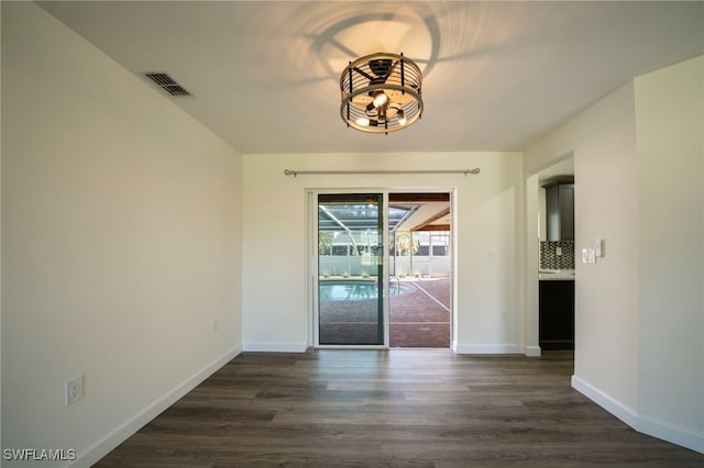 unfurnished dining area with visible vents, baseboards, and dark wood-style flooring