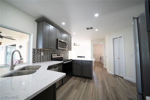 kitchen featuring visible vents, a ceiling fan, a sink, appliances with stainless steel finishes, and a peninsula