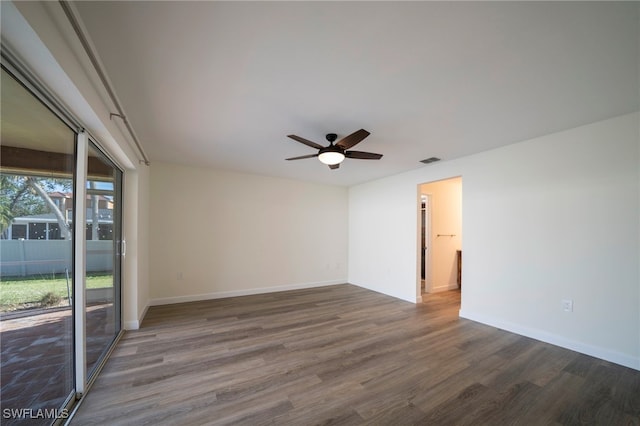 empty room with baseboards, wood finished floors, visible vents, and ceiling fan