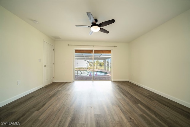 empty room featuring baseboards, ceiling fan, and dark wood-style flooring