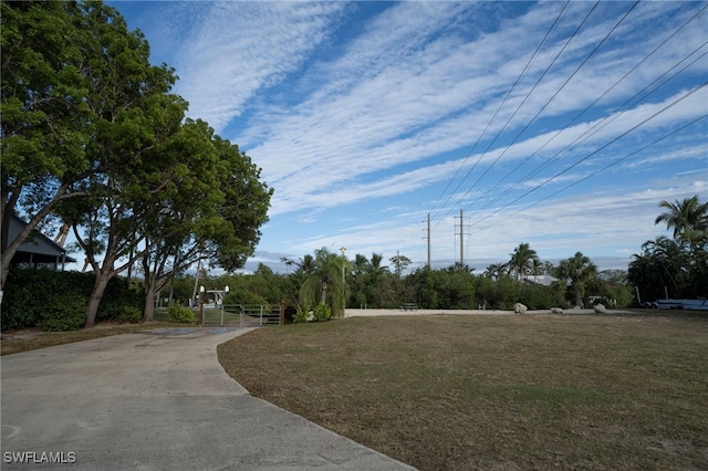 surrounding community featuring a lawn, driveway, and fence