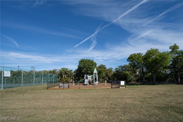 community playground featuring a lawn and fence