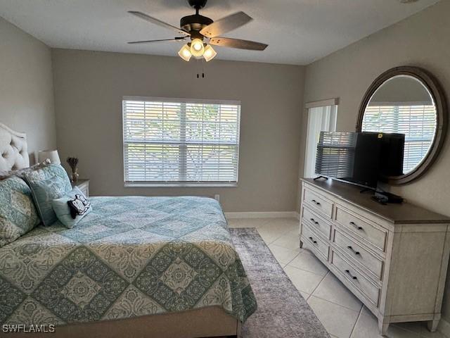 bedroom featuring ceiling fan, baseboards, and light tile patterned floors