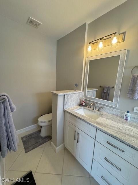 bathroom featuring visible vents, toilet, vanity, tile patterned flooring, and baseboards