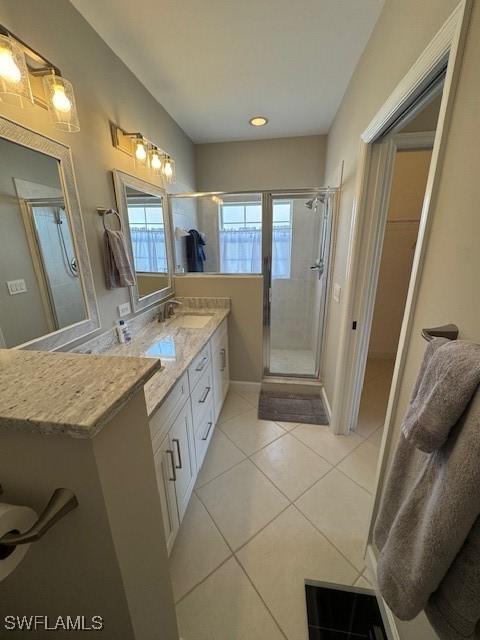 full bath featuring a shower stall, vanity, and tile patterned floors