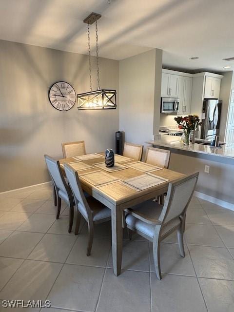 dining area featuring light tile patterned flooring and baseboards