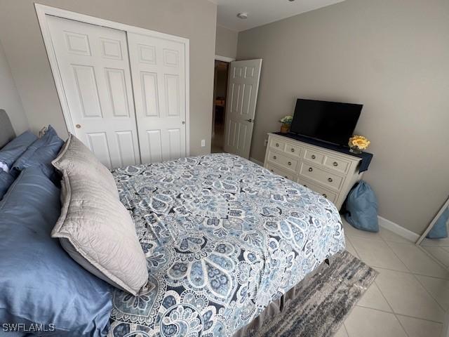 tiled bedroom with a closet and baseboards