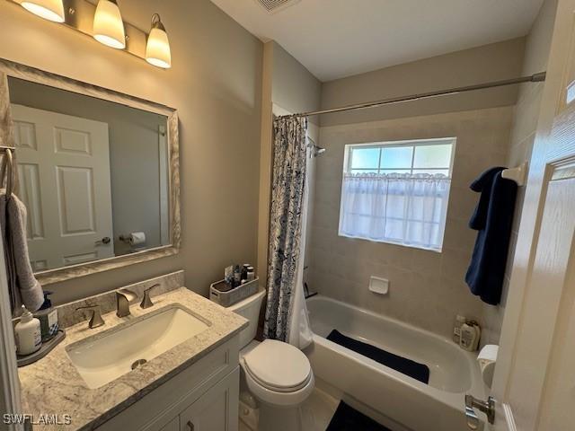 full bathroom with toilet, visible vents, shower / tub combo with curtain, and vanity