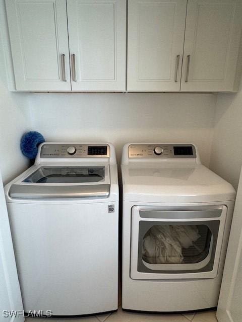 washroom with cabinet space and washing machine and dryer