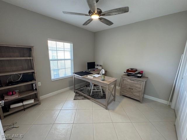 office featuring ceiling fan, baseboards, and light tile patterned floors