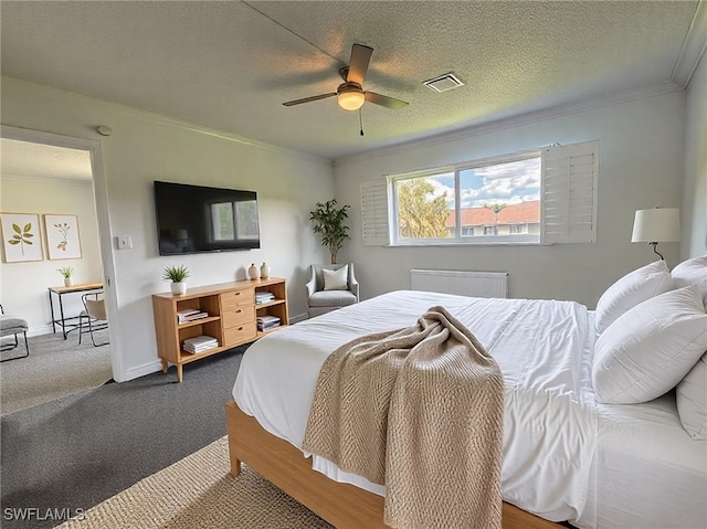 bedroom with a textured ceiling, a ceiling fan, baseboards, visible vents, and crown molding