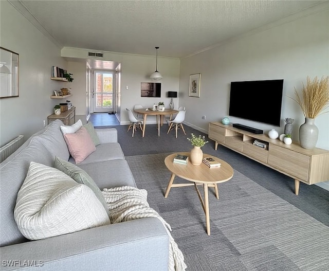 carpeted living area featuring ornamental molding, visible vents, a textured ceiling, and baseboards