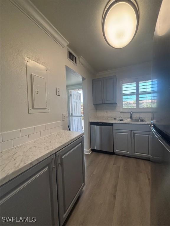 kitchen featuring tasteful backsplash, visible vents, ornamental molding, a sink, and dishwasher