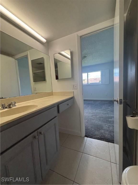 bathroom with baseboards, vanity, and tile patterned floors