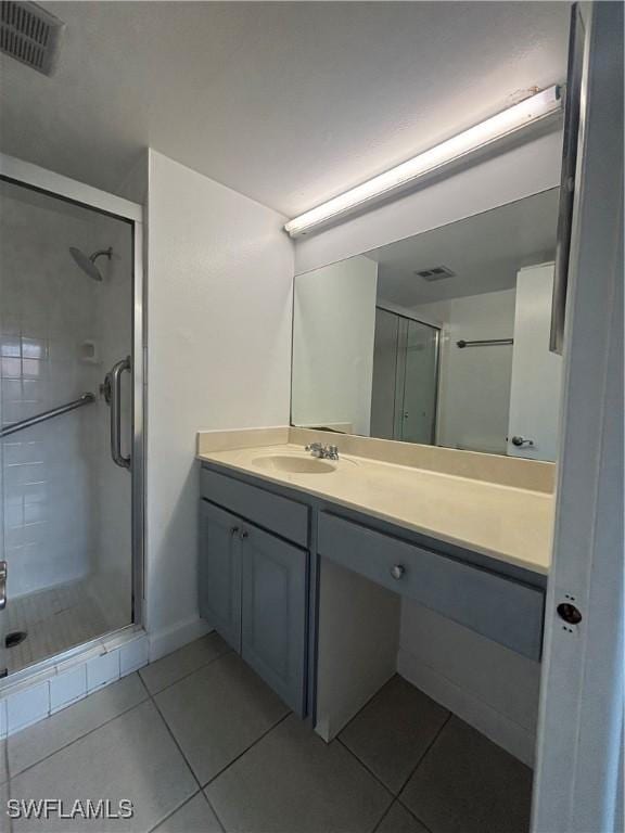 full bathroom featuring visible vents, a shower stall, vanity, and tile patterned floors