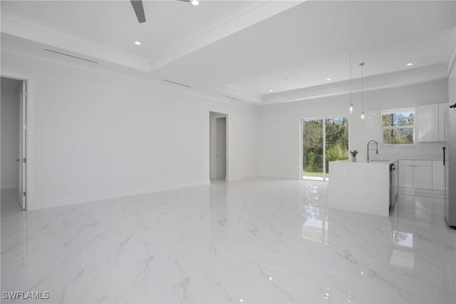 spare room with recessed lighting, a sink, marble finish floor, ornamental molding, and a raised ceiling