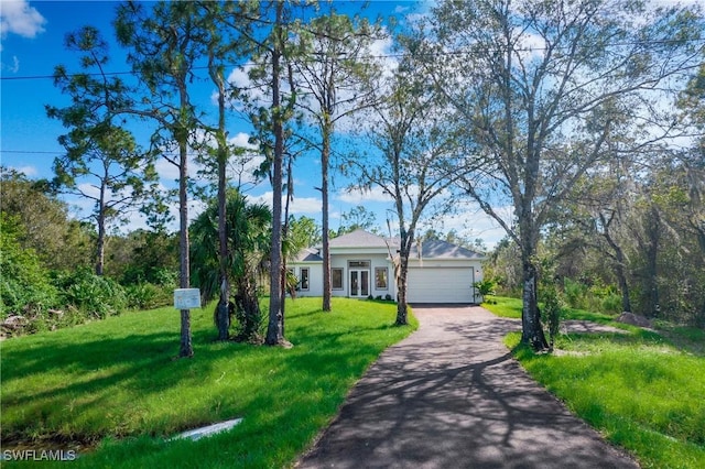 ranch-style house featuring an attached garage, aphalt driveway, and a front yard