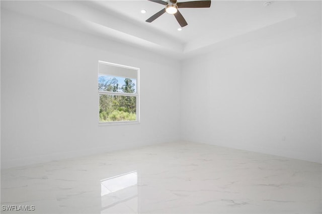 unfurnished room with marble finish floor, ceiling fan, a raised ceiling, and recessed lighting