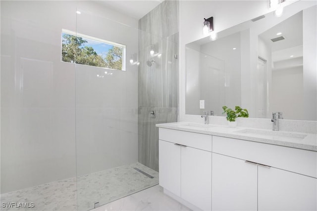 full bath with a walk in shower, marble finish floor, double vanity, and a sink