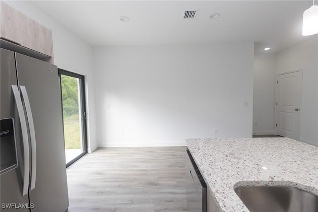 kitchen with visible vents, light wood-style flooring, modern cabinets, light stone countertops, and stainless steel appliances