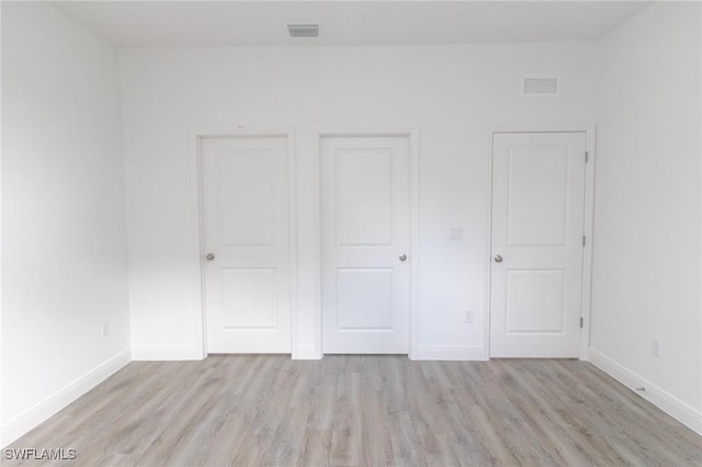 unfurnished bedroom featuring light wood-type flooring, visible vents, and baseboards