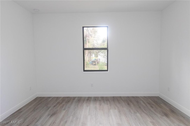 unfurnished room featuring light wood-type flooring and baseboards