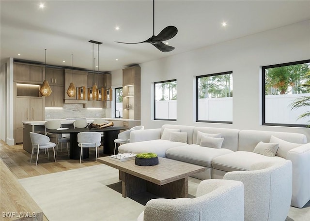 living room with a ceiling fan, recessed lighting, a healthy amount of sunlight, and light wood-style flooring