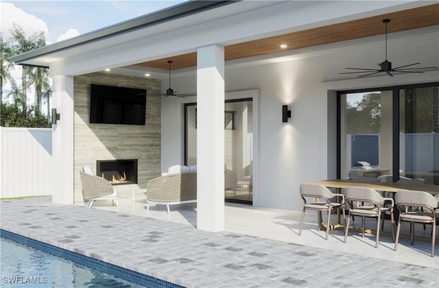 view of patio with a fireplace, fence, and ceiling fan