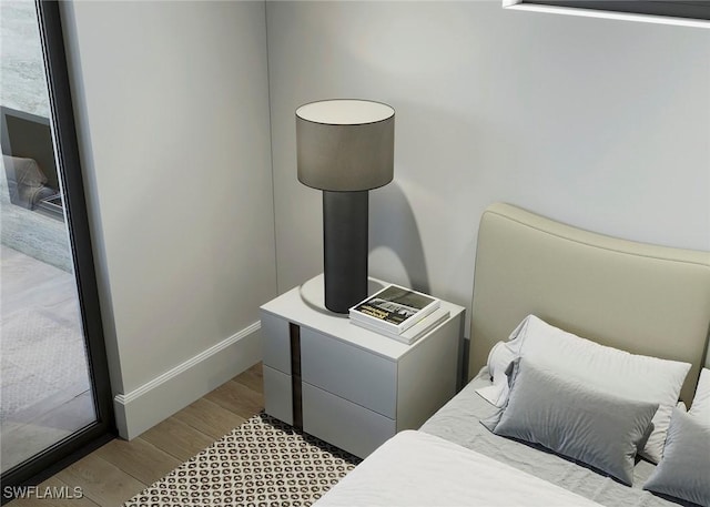 bedroom with baseboards and wood finished floors