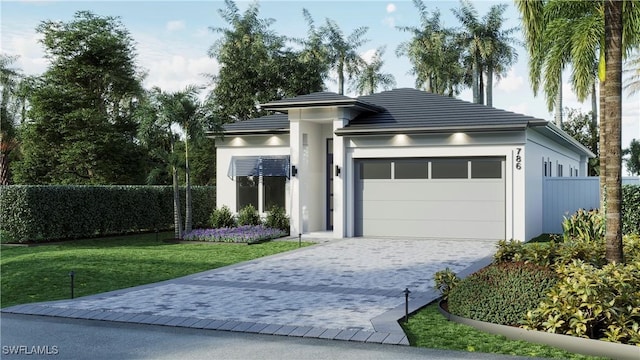 prairie-style home with decorative driveway, stucco siding, an attached garage, fence, and a front lawn