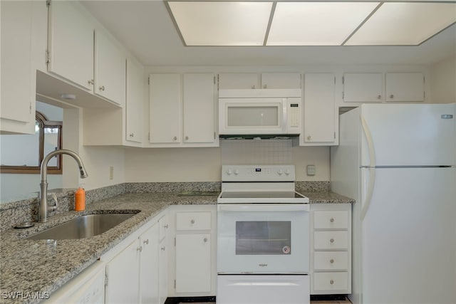 kitchen featuring white appliances, a sink, light stone countertops, and white cabinets