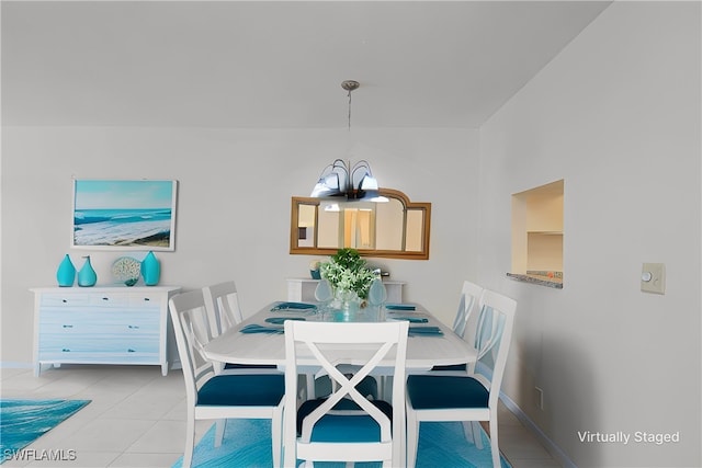 dining area with tile patterned flooring, baseboards, and a notable chandelier