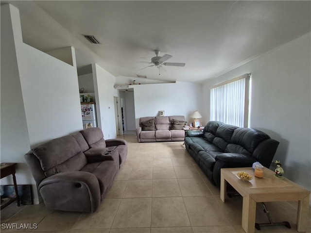 living room featuring vaulted ceiling, light tile patterned flooring, visible vents, and a ceiling fan