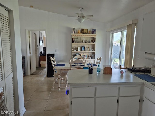 kitchen featuring ceiling fan, white cabinetry, light countertops, and light tile patterned flooring