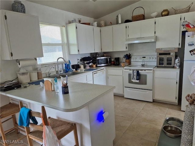 kitchen with light tile patterned floors, a sink, a peninsula, white appliances, and under cabinet range hood