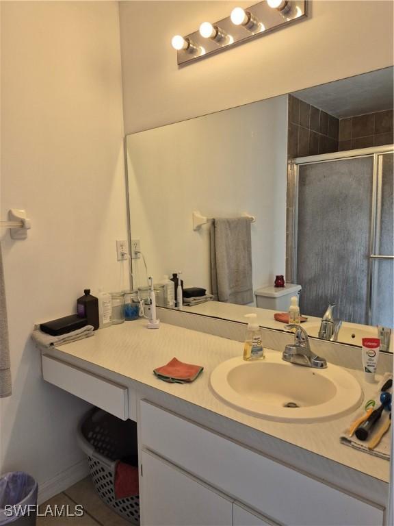 full bathroom featuring a stall shower, tile patterned floors, and vanity