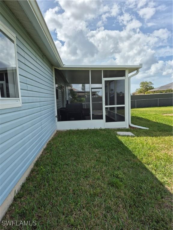 view of yard with a sunroom and fence